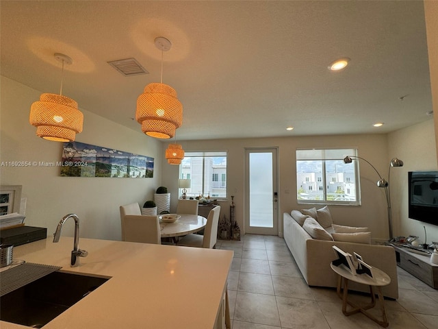 kitchen featuring light tile patterned floors, plenty of natural light, sink, and pendant lighting