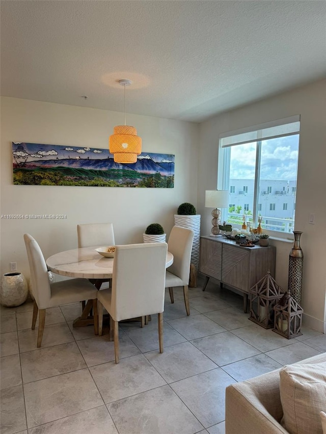 dining room with a textured ceiling and light tile patterned floors