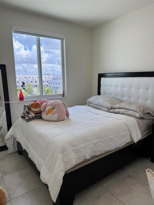 tiled bedroom featuring a textured ceiling