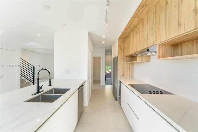 kitchen featuring range hood, white cabinetry, sink, stainless steel dishwasher, and black electric cooktop