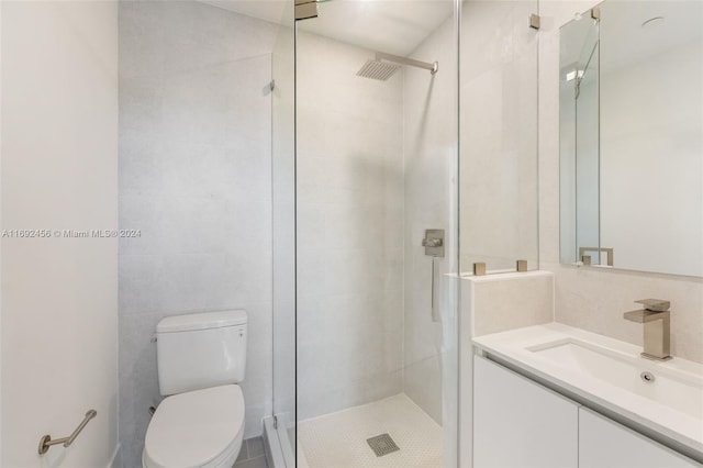 bathroom featuring a shower with shower door, vanity, and toilet