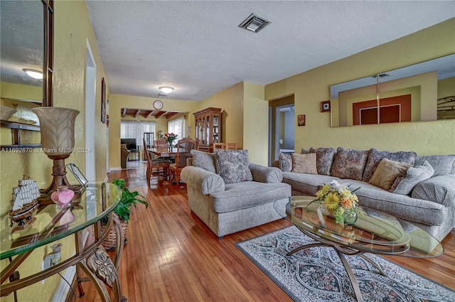 living room with a textured ceiling and hardwood / wood-style flooring