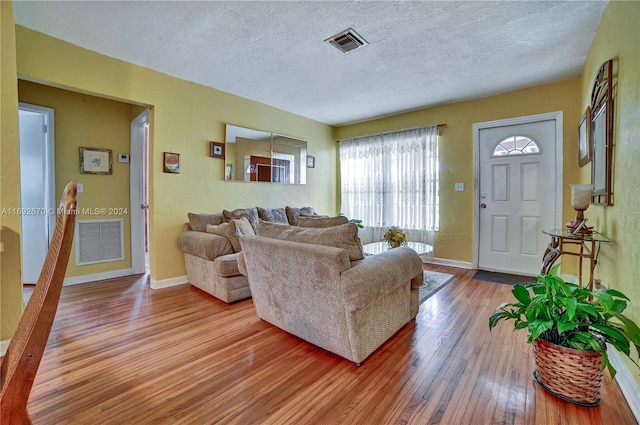 living room with light hardwood / wood-style floors and a textured ceiling