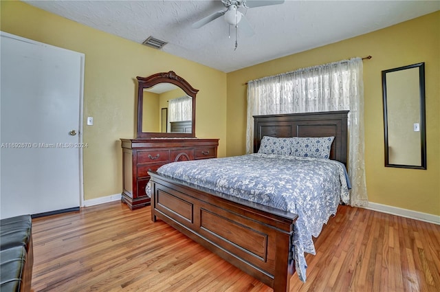 bedroom featuring a textured ceiling, light hardwood / wood-style flooring, and ceiling fan