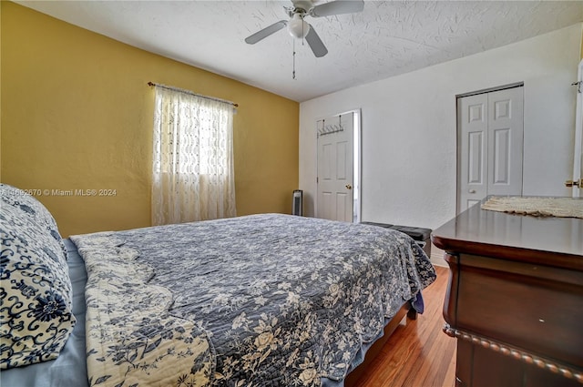 bedroom featuring hardwood / wood-style floors, ceiling fan, a textured ceiling, and a closet