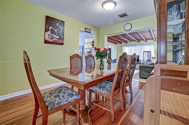 6525 Mayo St, Hollywood, FL 33023 - dining area featuring wood finished floors, a textured ceiling, and beam ceiling