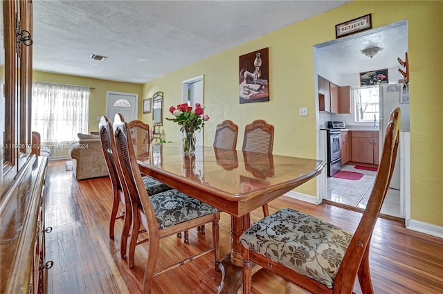 dining area featuring hardwood / wood-style floors and a textured ceiling