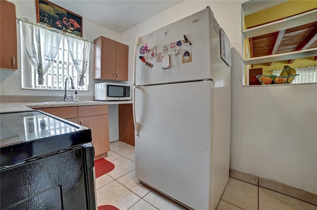 kitchen with white appliances, sink, and light tile patterned flooring