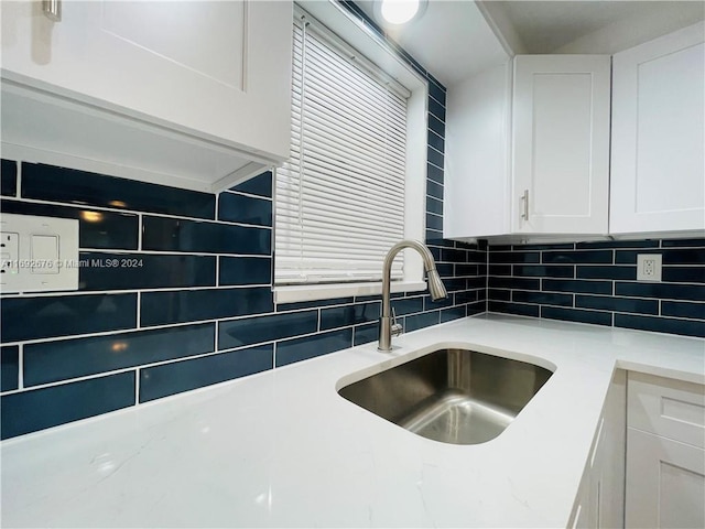 kitchen featuring white cabinets, sink, and decorative backsplash