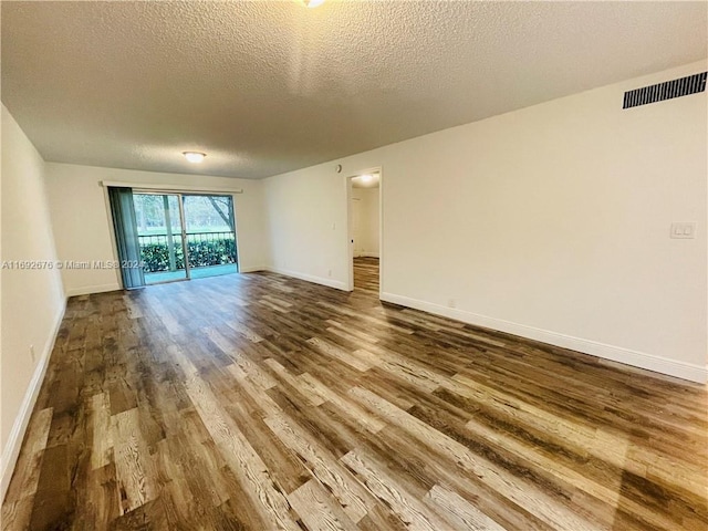 spare room featuring hardwood / wood-style floors and a textured ceiling