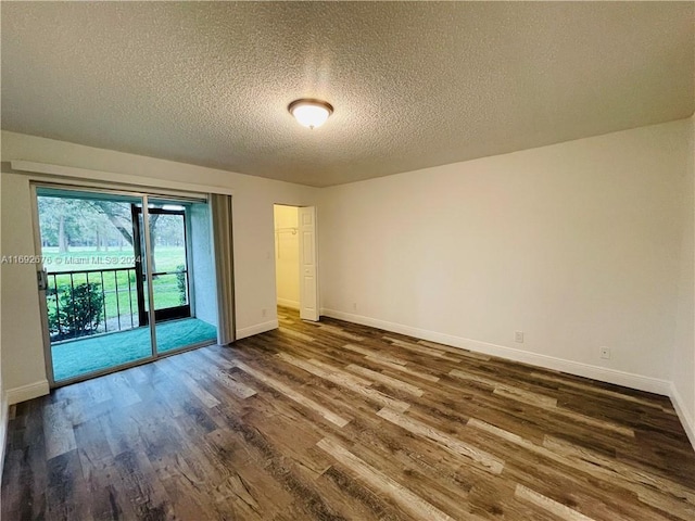 spare room with dark hardwood / wood-style floors and a textured ceiling