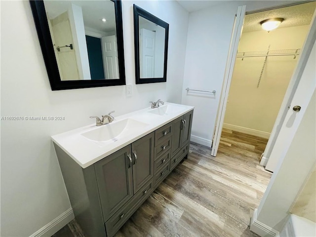 bathroom featuring vanity, wood-type flooring, and a textured ceiling