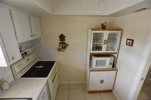 kitchen featuring white cabinetry, tile countertops, light tile patterned floors, and white appliances