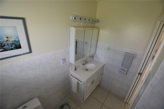 bathroom with tile patterned flooring, vanity, and tile walls