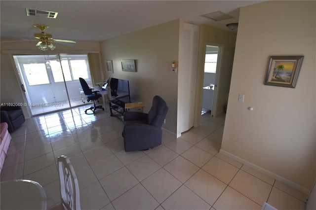 living room featuring a wealth of natural light, ceiling fan, and light tile patterned floors