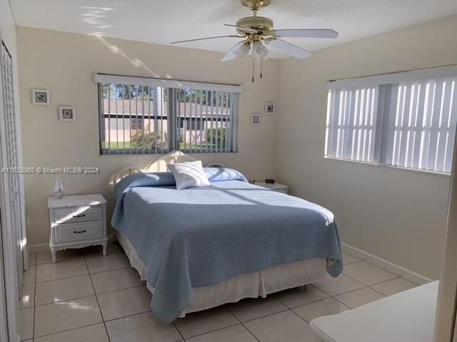 tiled bedroom with ceiling fan