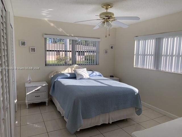 tiled bedroom featuring ceiling fan