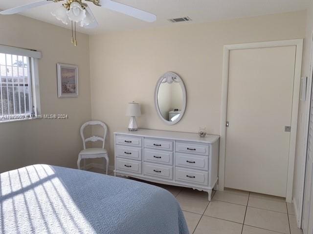 tiled bedroom with ceiling fan