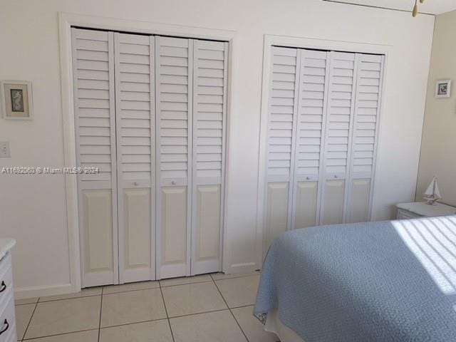 bedroom featuring two closets and light tile patterned floors