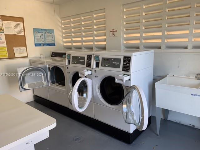 clothes washing area featuring sink and independent washer and dryer