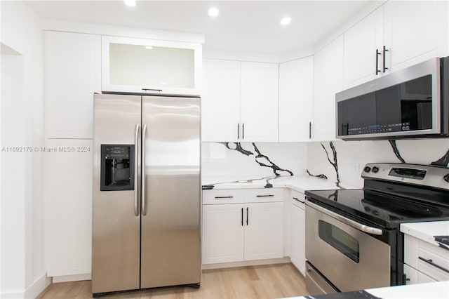 kitchen with white cabinets, appliances with stainless steel finishes, and light hardwood / wood-style floors