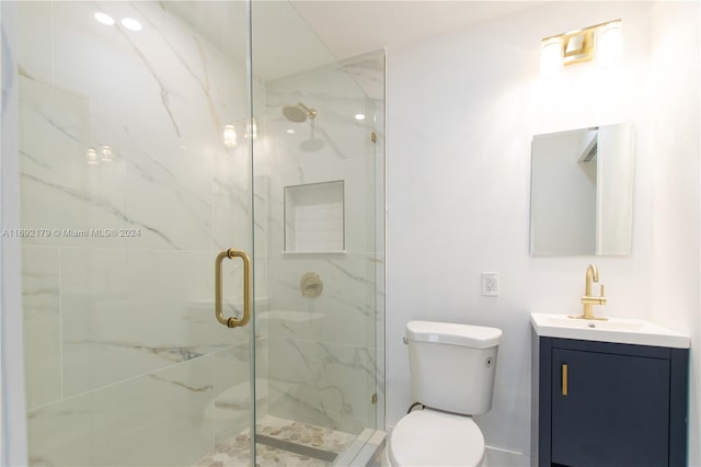 bathroom with vanity, toilet, and an enclosed shower