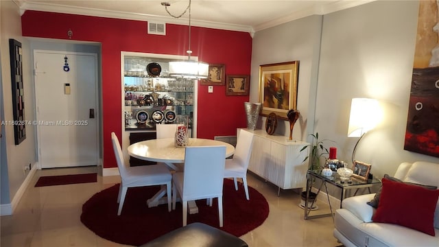 dining room with baseboards, visible vents, and crown molding