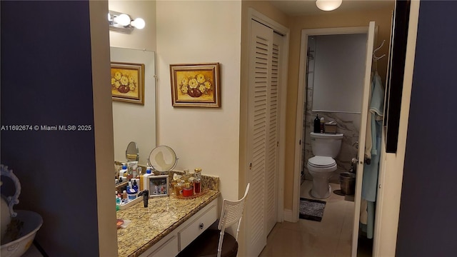 full bathroom featuring a closet, vanity, toilet, and tile patterned floors