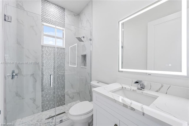 bathroom with vanity, a shower with shower door, and toilet