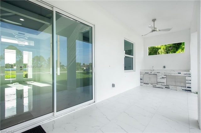 view of patio featuring ceiling fan and an outdoor kitchen