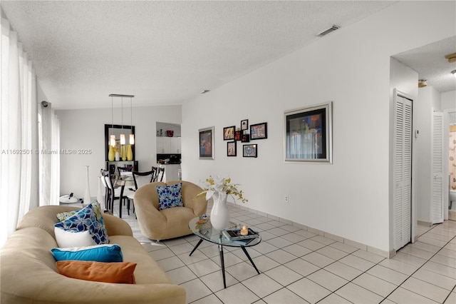 living room with light tile patterned flooring and a textured ceiling