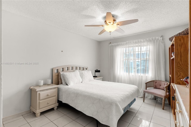 bedroom featuring a textured ceiling, ceiling fan, and light tile patterned flooring