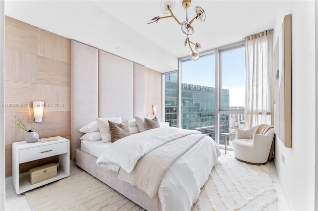 bedroom featuring a notable chandelier and floor to ceiling windows