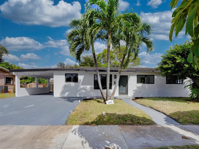 view of front facade featuring central AC unit, a front lawn, and a carport