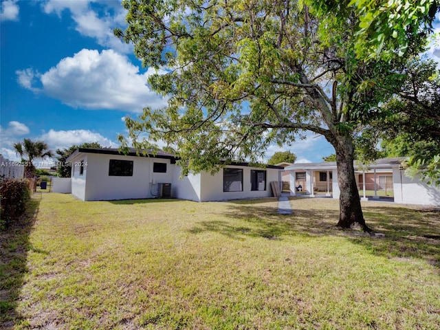 back of house with central AC and a yard