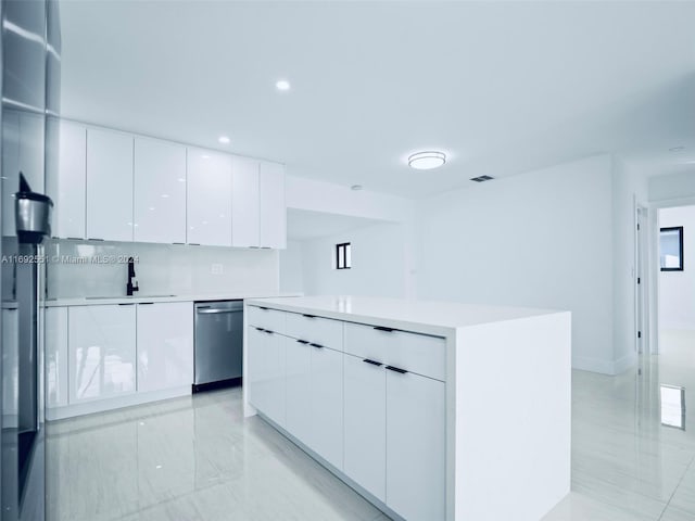 kitchen featuring white cabinetry, decorative backsplash, sink, stainless steel dishwasher, and a center island