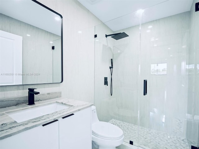 bathroom featuring an enclosed shower, vanity, and toilet