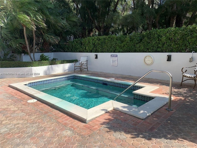 view of swimming pool featuring a hot tub