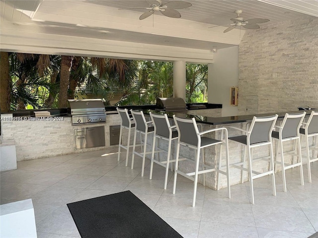 view of patio / terrace featuring area for grilling, ceiling fan, an outdoor bar, and grilling area