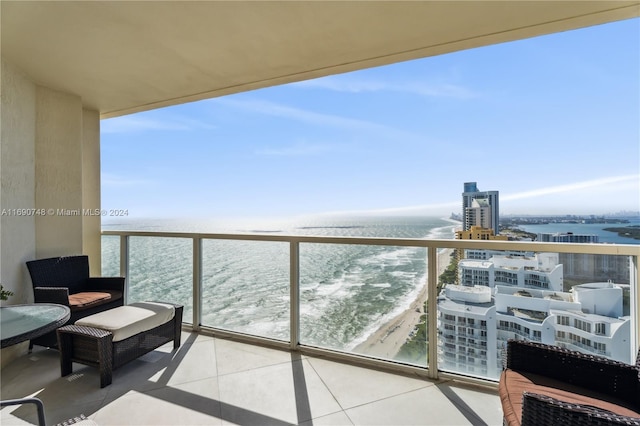 balcony featuring a water view and a beach view