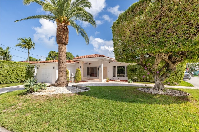 mediterranean / spanish house with a front lawn and a garage