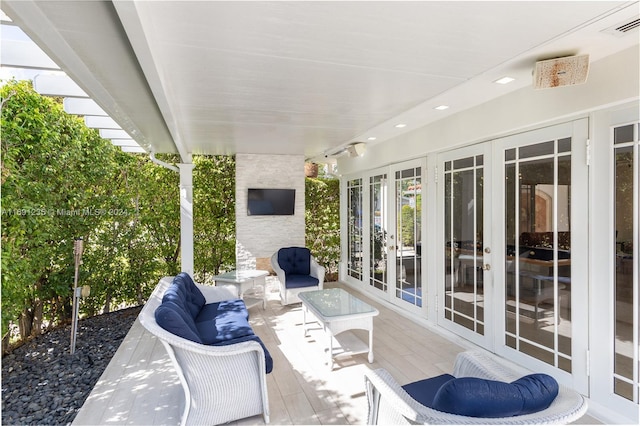 view of patio / terrace with an outdoor living space with a fireplace and french doors