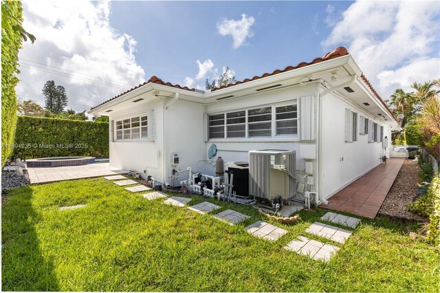 8801 Dickens Ave, Surfside, FL 33154 - back of property with central AC, stucco siding, and a tiled roof