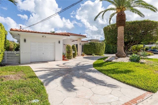 view of front of property featuring a garage, stucco siding, a tiled roof, and concrete driveway