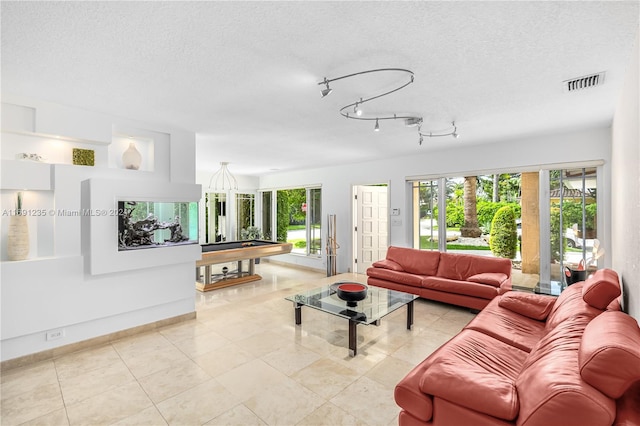 living room featuring light tile patterned floors, a textured ceiling, and billiards