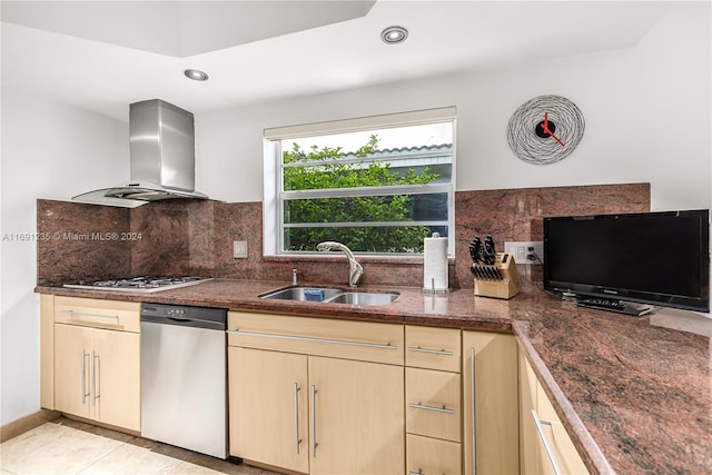 kitchen featuring sink, wall chimney exhaust hood, stainless steel appliances, tasteful backsplash, and light tile patterned flooring