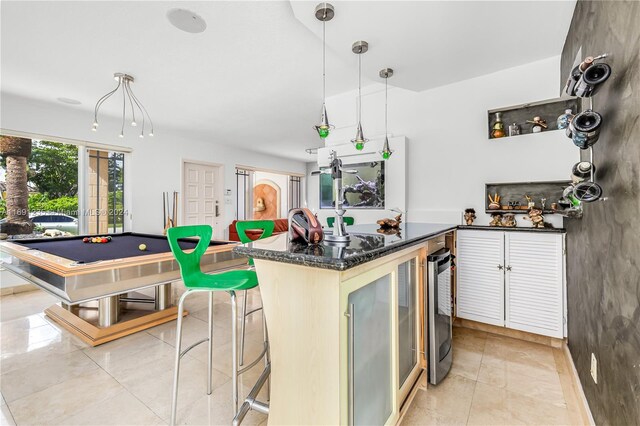 kitchen featuring a breakfast bar, beverage cooler, decorative light fixtures, and pool table