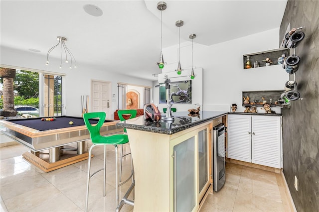 kitchen featuring hanging light fixtures, dark stone countertops, pool table, light tile patterned floors, and wine cooler