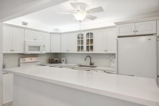 kitchen with white cabinets, sink, and white appliances