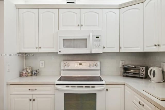 kitchen featuring white cabinetry, white appliances, and decorative backsplash